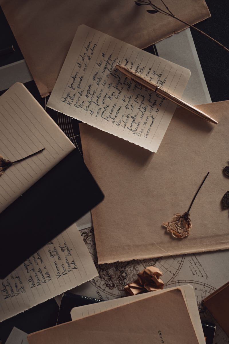 Stack of handwritten letters and journals scattered across a surface